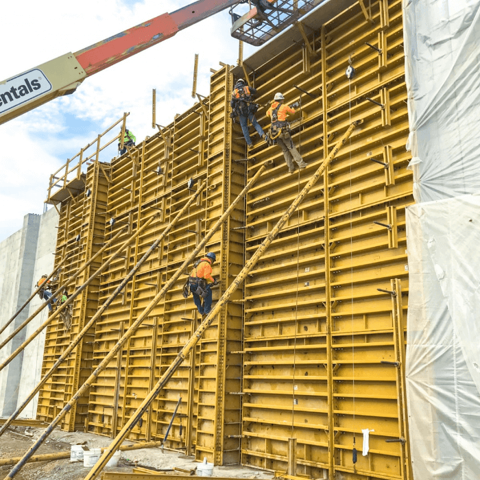 construction workers climbing wall